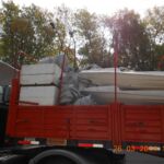 Motores en cajas de terlgopor cargados en camión junto a los tubos desinflados y cascos de fibra Motores en cajas